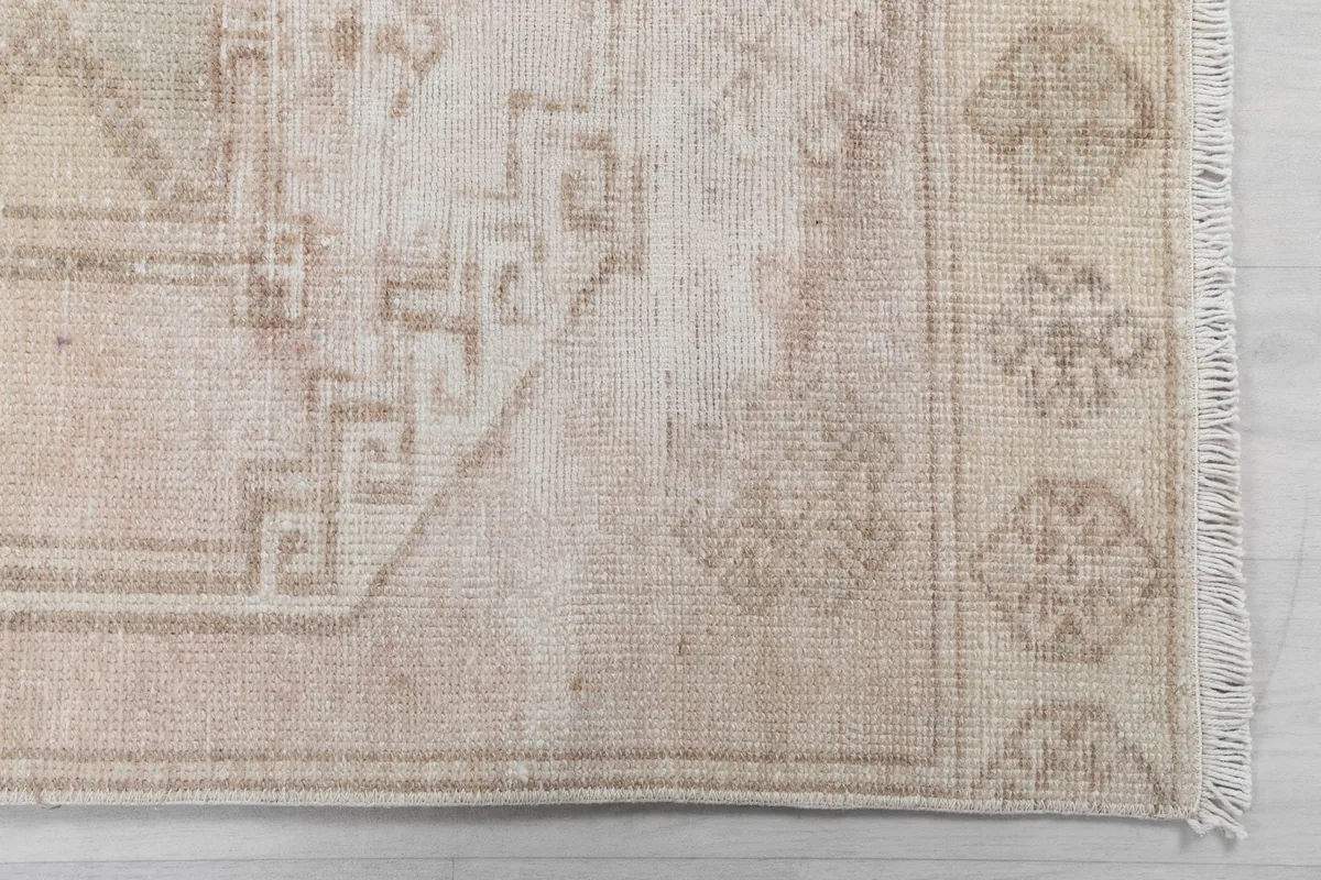 Detailed view of the rug's border and a section of the geometric pattern, showing the fringe.