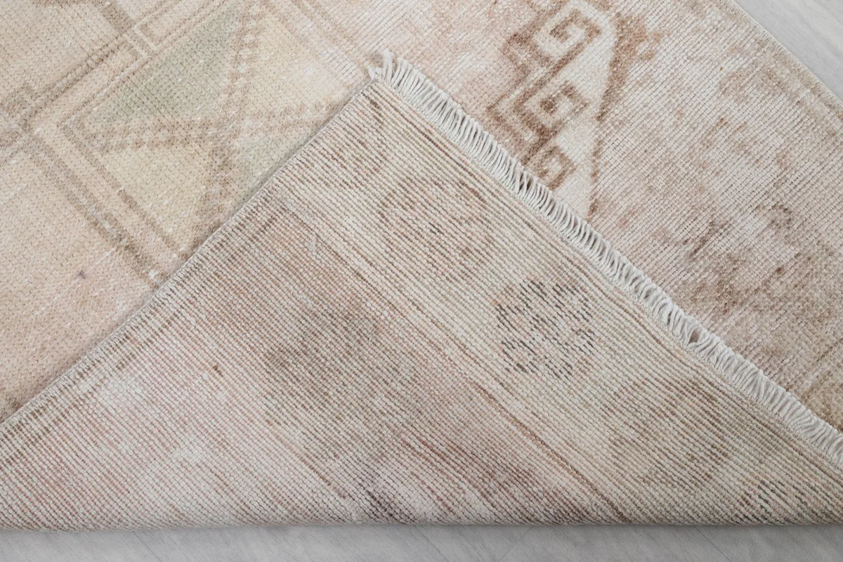 Underside view of a folded corner, revealing the cotton foundation and hand-knotted construction.