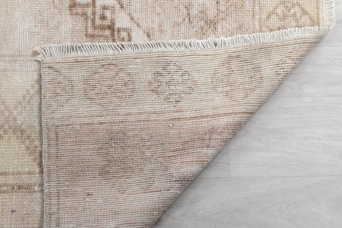 Close-up of the rug's reverse side, showing the knotting and the structure of the vintage wool rug.