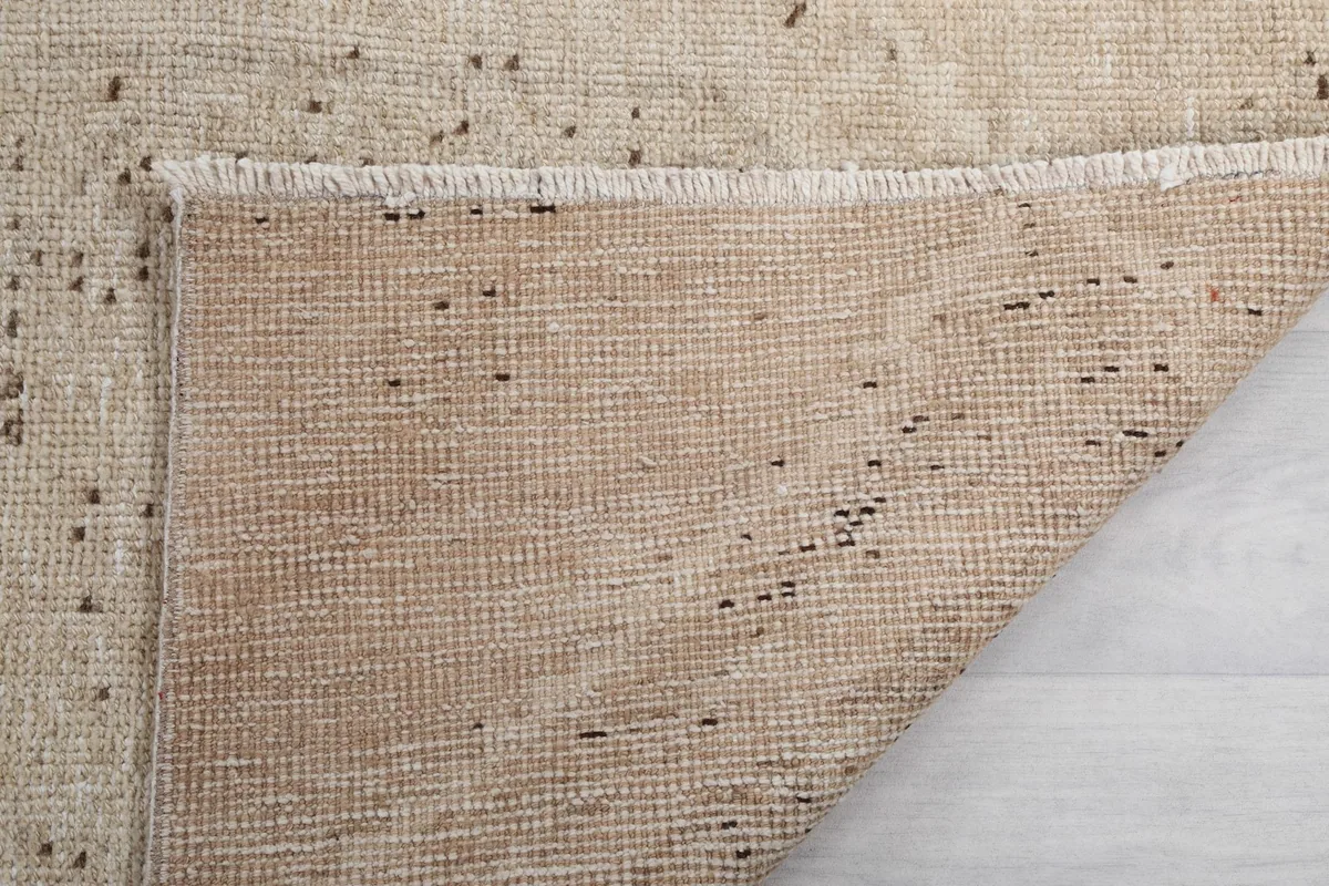 Close-up of the rug's edge and fringe, showing the back of the rug