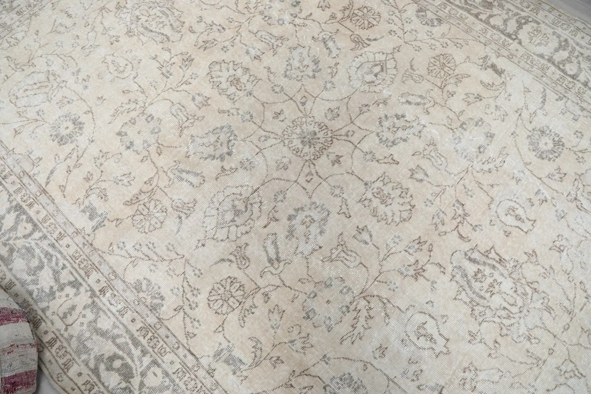 Close-up of the central floral and geometric motifs on the rug's ivory field