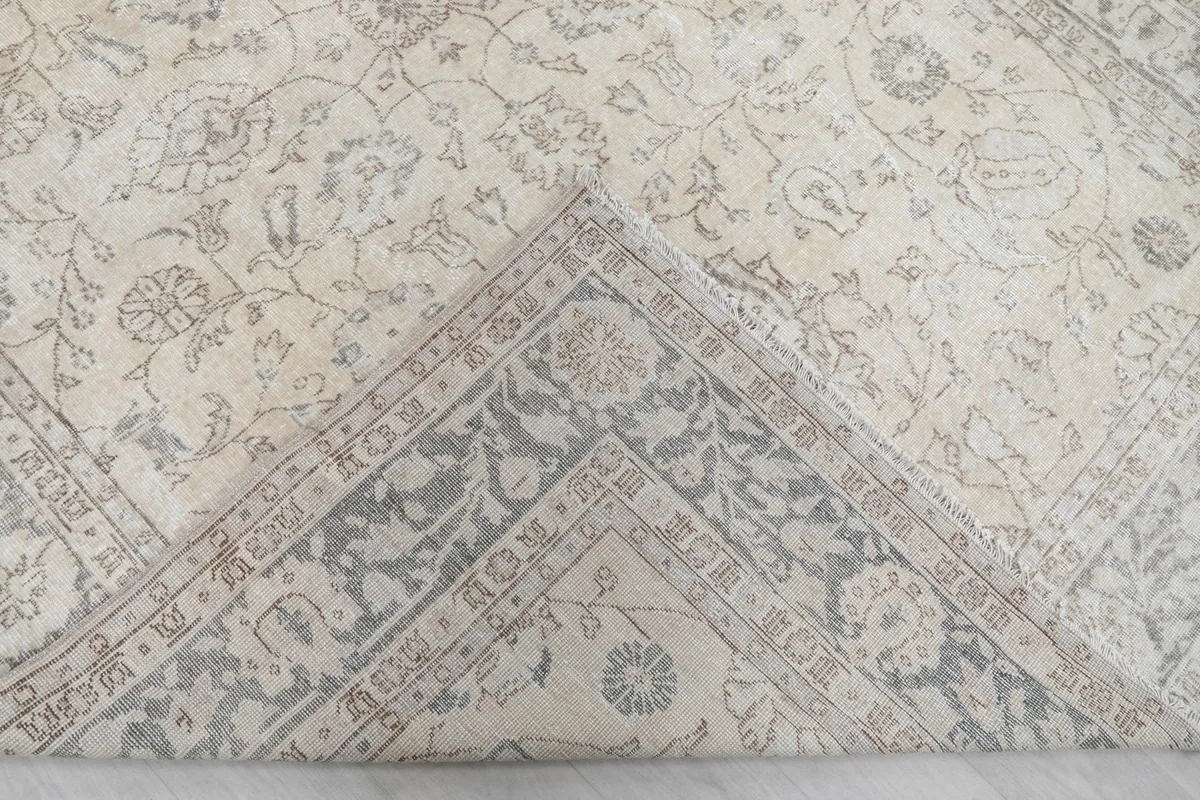 Flipped corner of the rug showing the cotton foundation and hand-knotted construction
