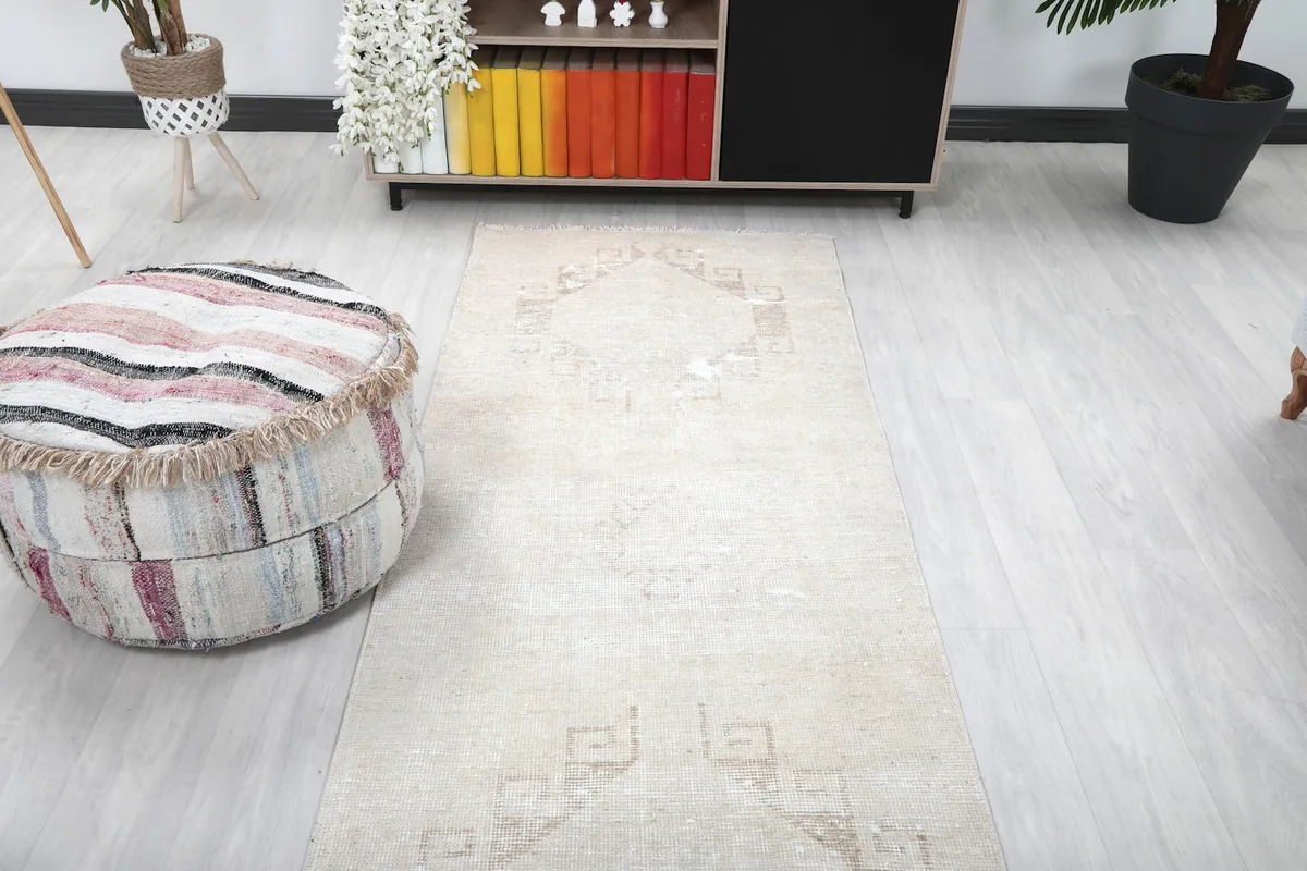 View of the runner rug extending from a decorative ottoman towards a sofa in a room