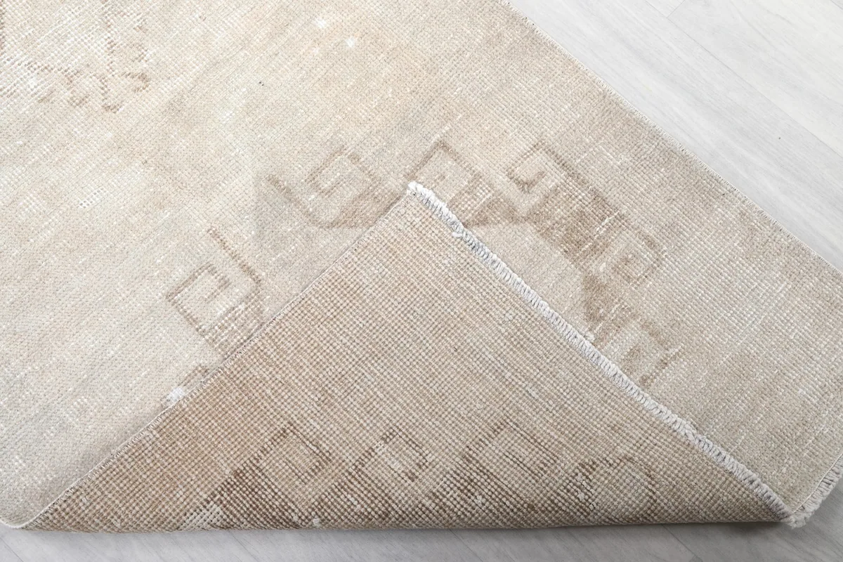 Corner of the rug folded to reveal the hand-knotted cotton foundation and wool pile