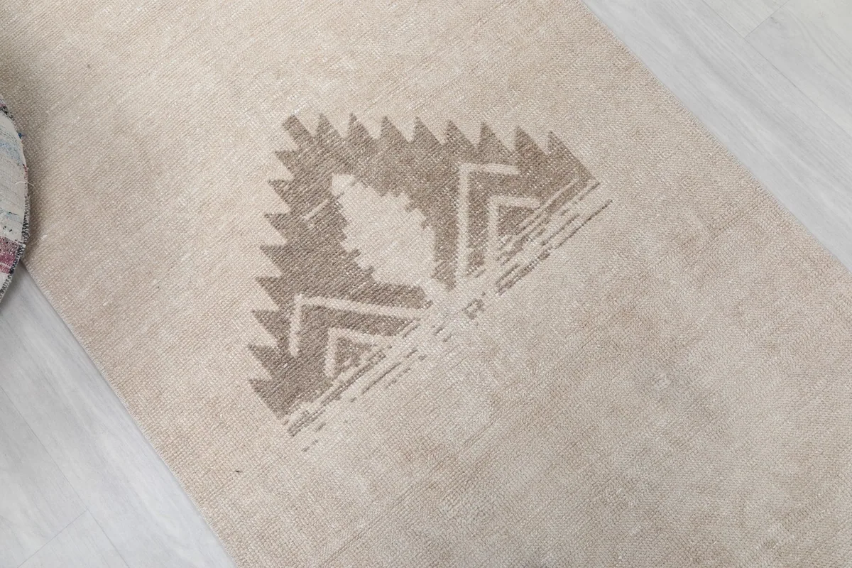 Angled view highlighting the main tribal geometric pattern in brown on the tan runner