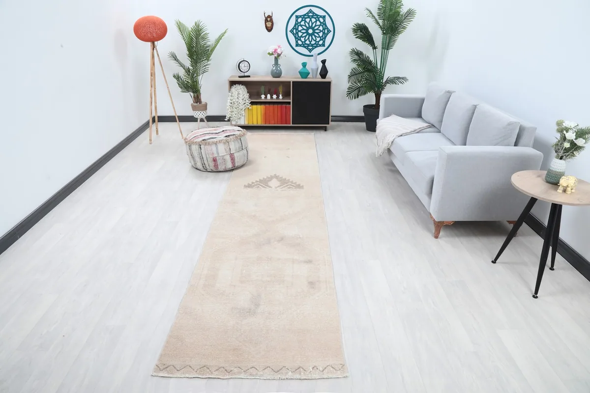 Vintage tan runner rug displayed in a modern living room setting with a gray sofa