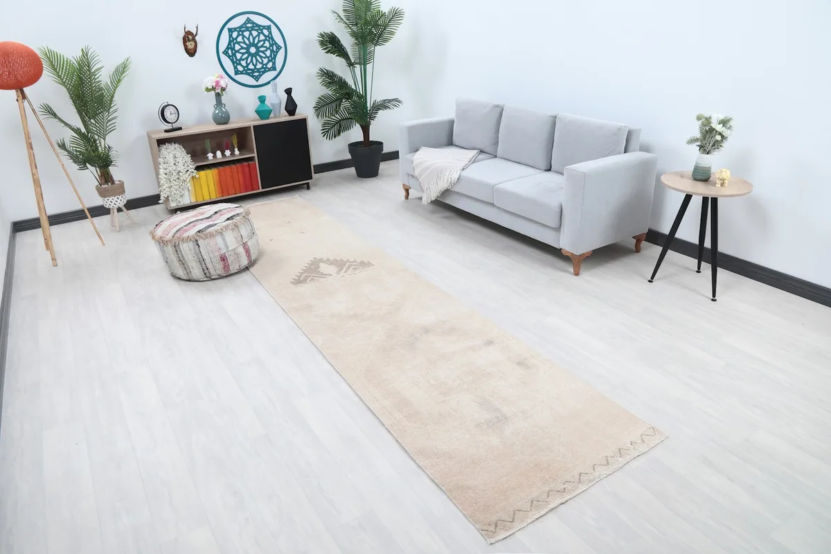 Long view of the tan runner rug extending through a hallway or narrow living space
