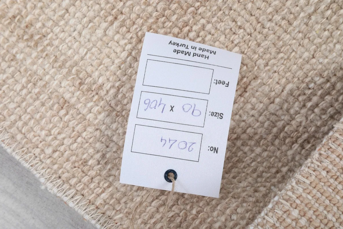 Close-up of the product tag attached to the rug, showing size and origin details