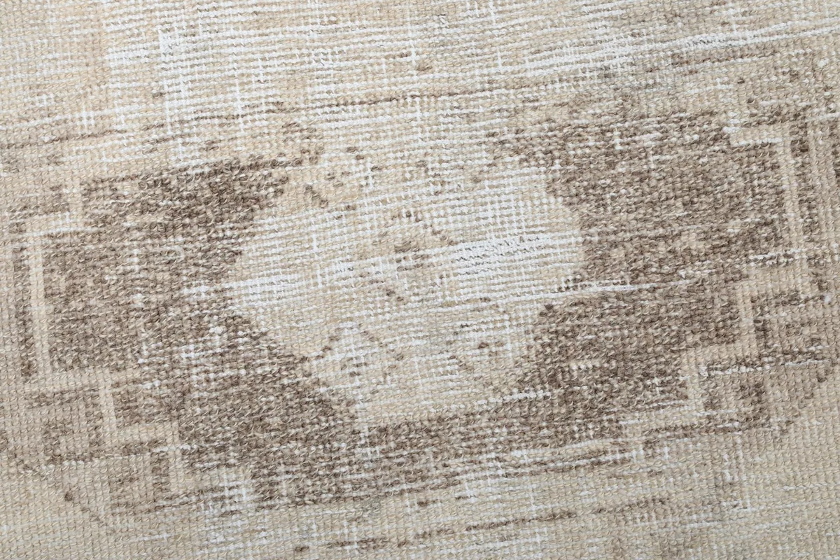 Detailed view showing the texture and faded brown geometric pattern of the runner rug