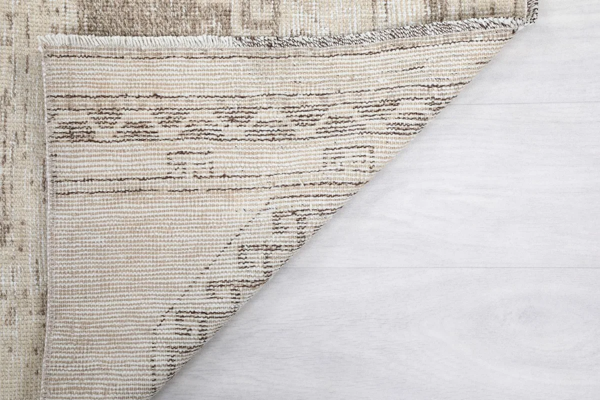 View of the underside of the vintage runner rug, showing the cotton foundation