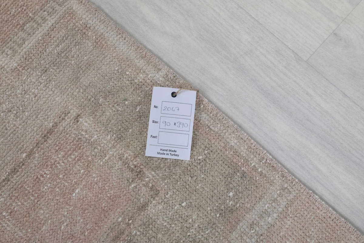 Close-up of the rug's tag, indicating hand-made in Turkey and material