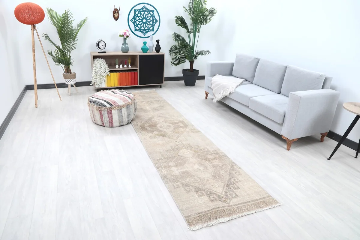 Angled view of the runner rug in a living space, showing its length and neutral tones.