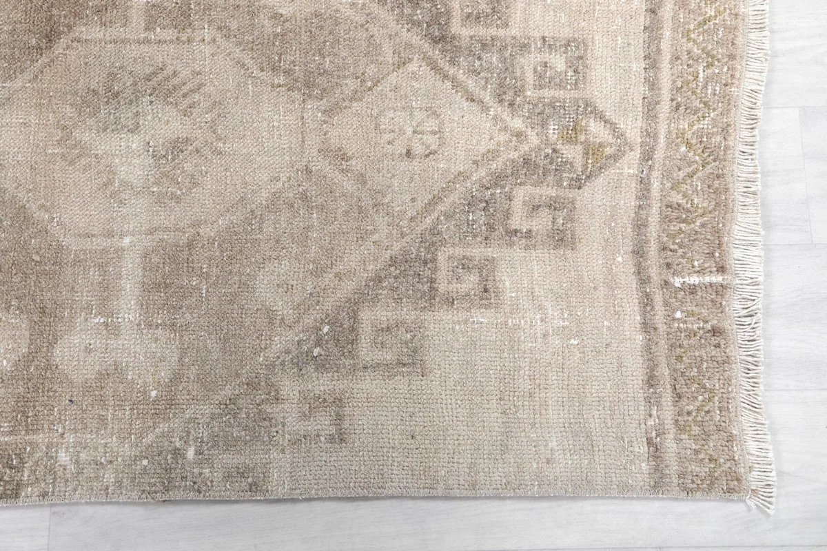 Detailed view of the rug's border and one end, highlighting the geometric motifs and texture.