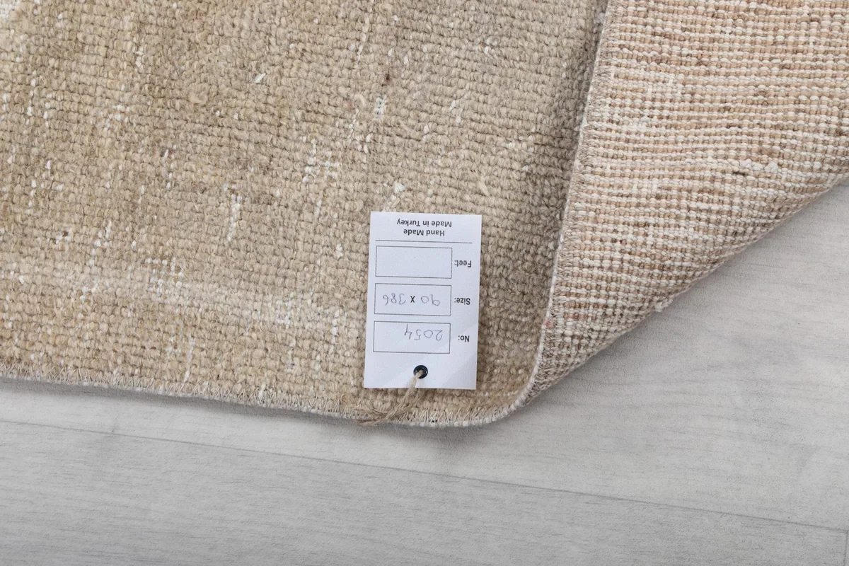 Close-up of the back of the rug with a tag, confirming the hand-knotted construction and material