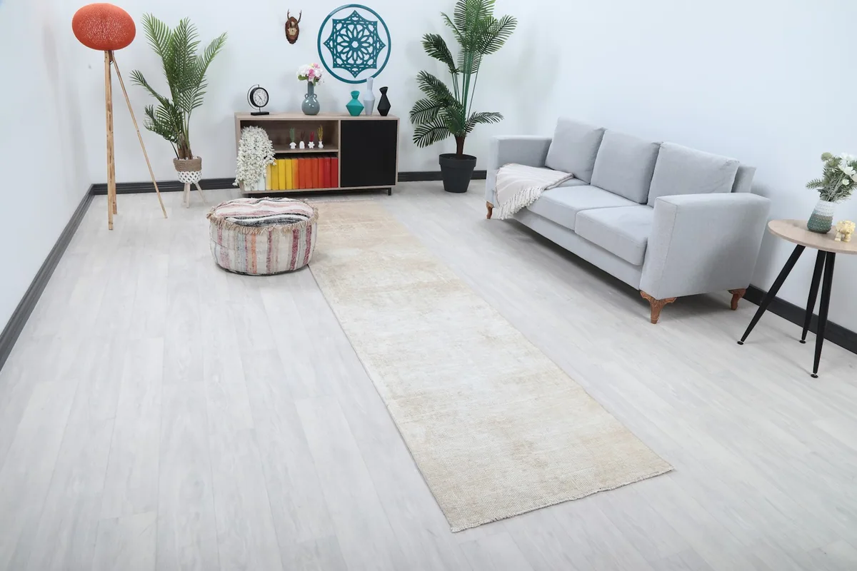 Angled view of the beige runner rug showcasing its length in a room setting