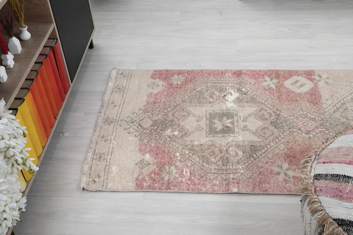 Overhead view of the upper section of the runner rug, showing the rose and beige transition