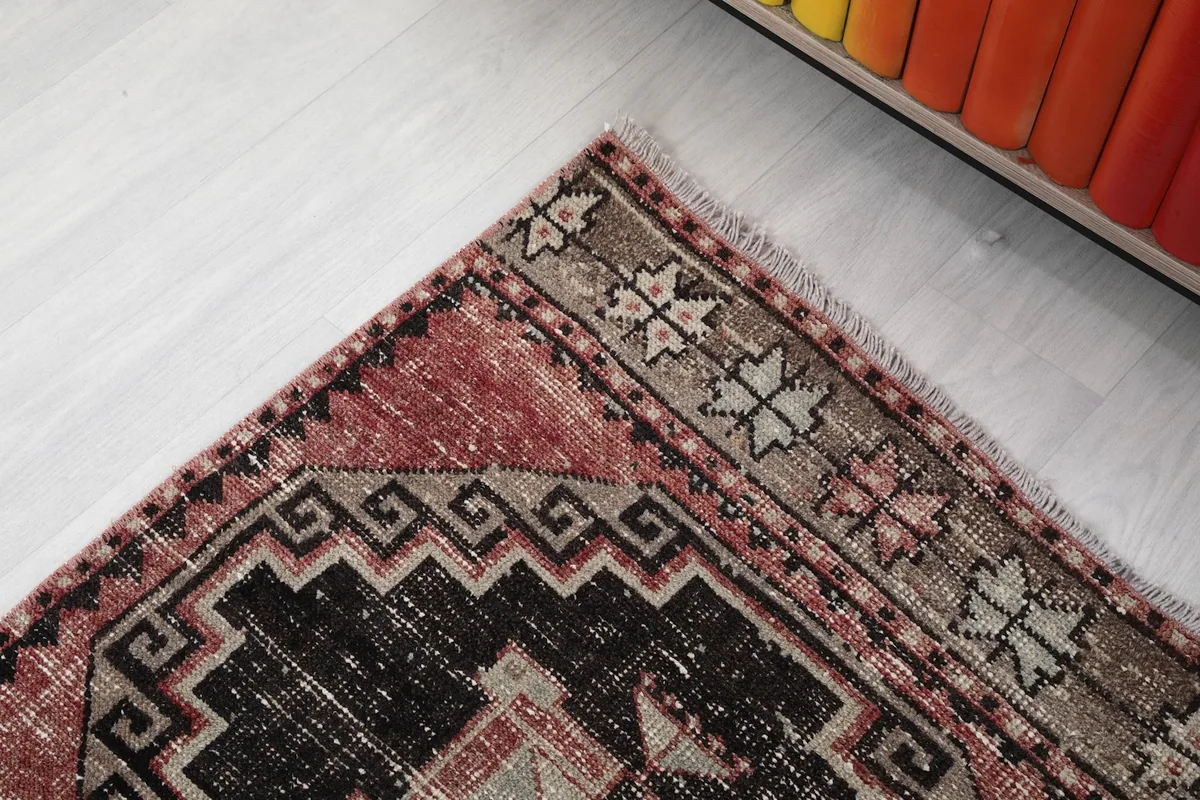 Close-up of the rug's border design featuring small geometric motifs in beige and black