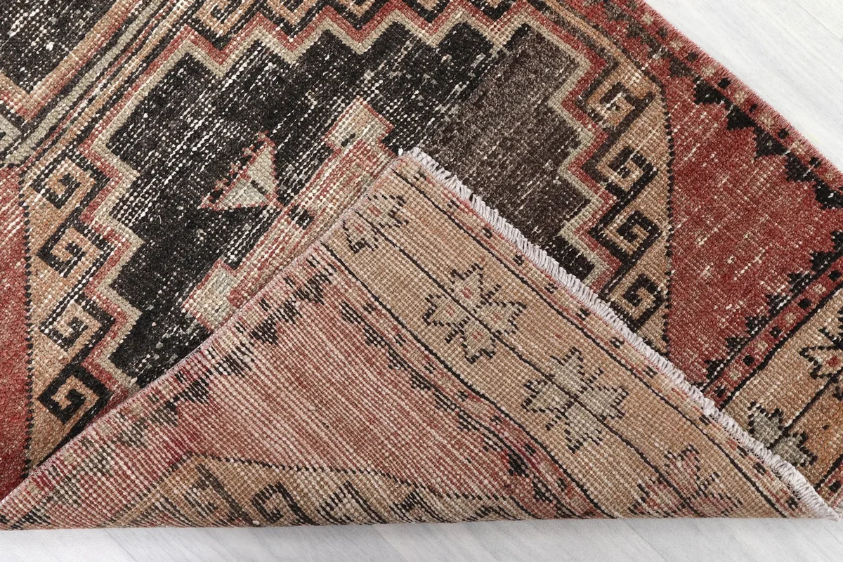 Corner of the runner folded to show the back of the hand-knotted cotton foundation and wool pile