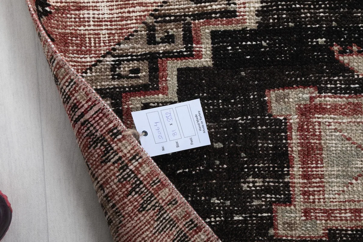 Corner of the runner rug with a product tag, showing the reverse side and pile texture