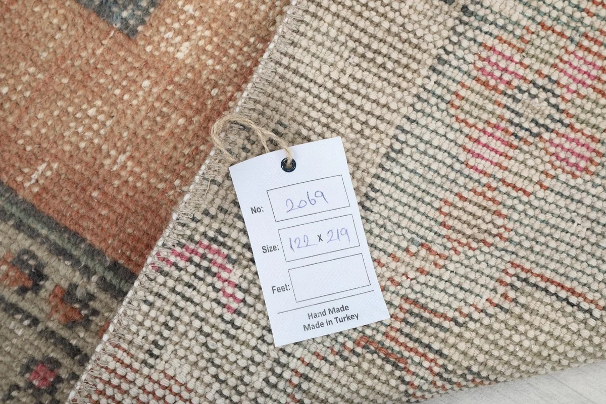 Tag showing the rug's dimensions in centimeters and confirming it is hand-made in Turkey