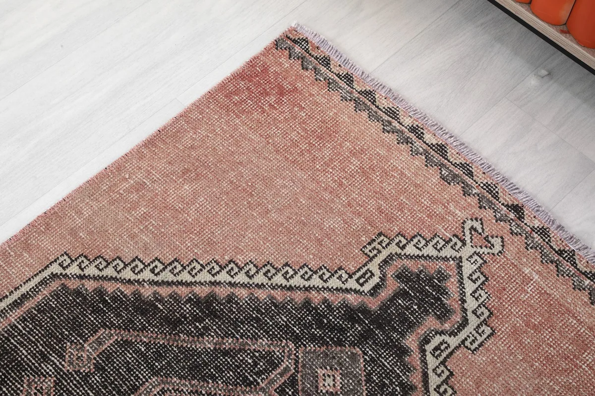 Corner detail showing the rose field, charcoal border, and geometric patterns