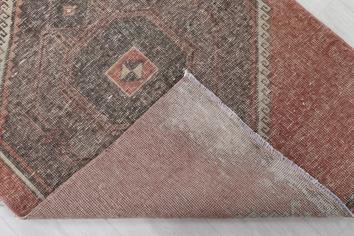 View of the back of the rug, showing the cotton foundation and hand-knotted construction
