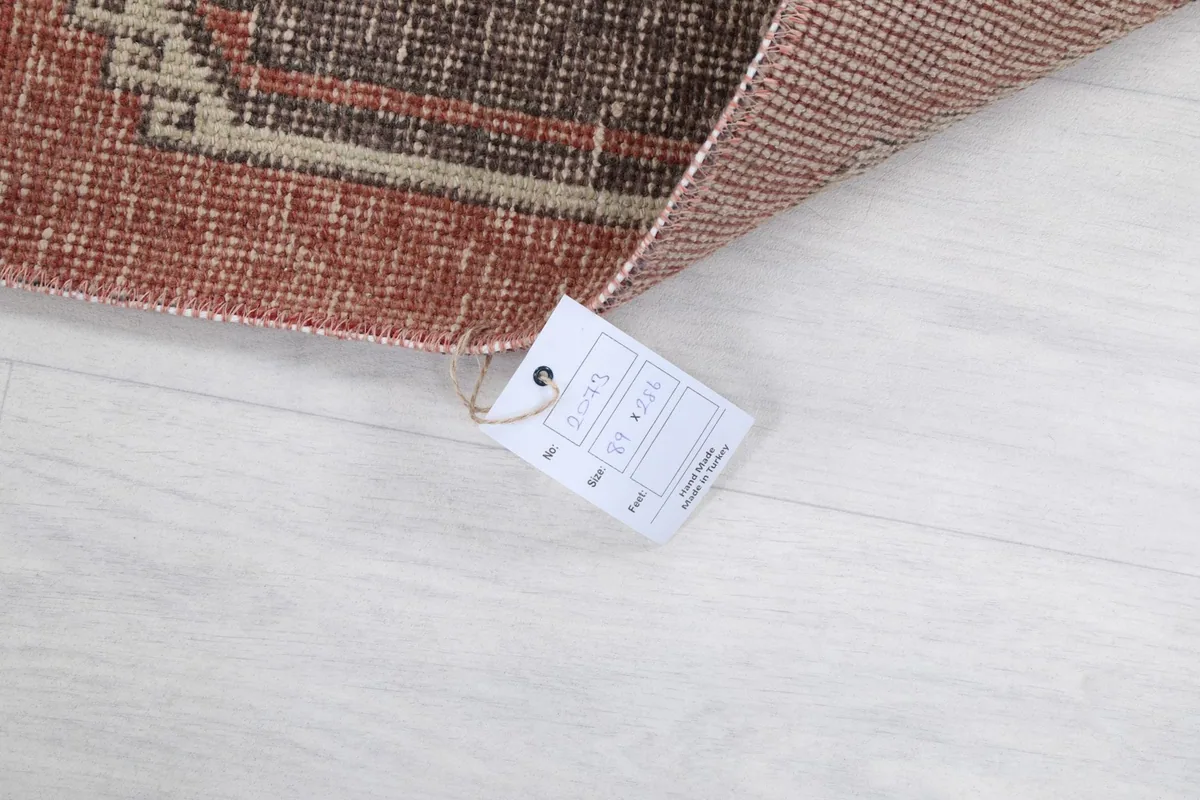 Corner of the rug with its product tag, showing details on a white floor