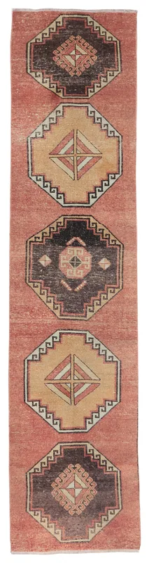 Full overhead view of the vintage Anatolian runner rug with rust field and tribal medallions.
