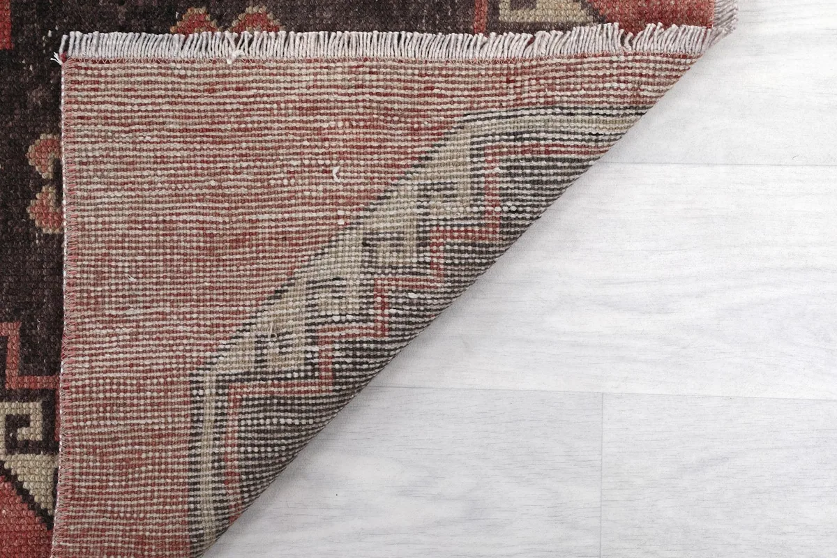 Underside view of the rug, showing the cotton foundation and hand-knotted construction.