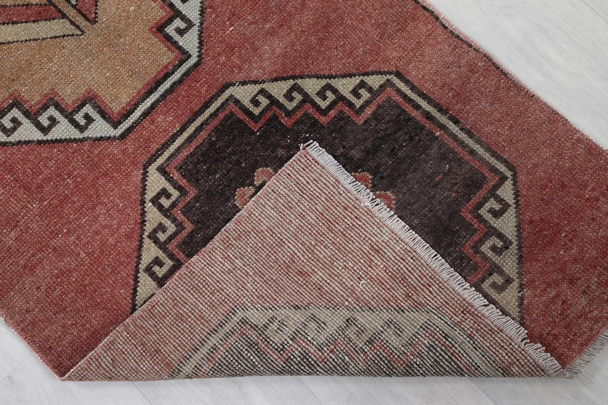 Folded corner of the rug revealing the wool pile and cotton foundation.
