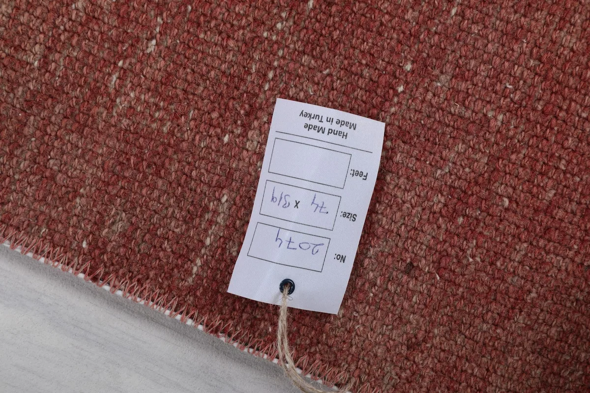 Close-up of the rug's texture with a product tag displaying size and origin details.