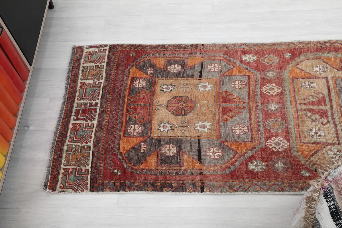 Angled view of the rug's length, showing the repeating geometric patterns and color variations
