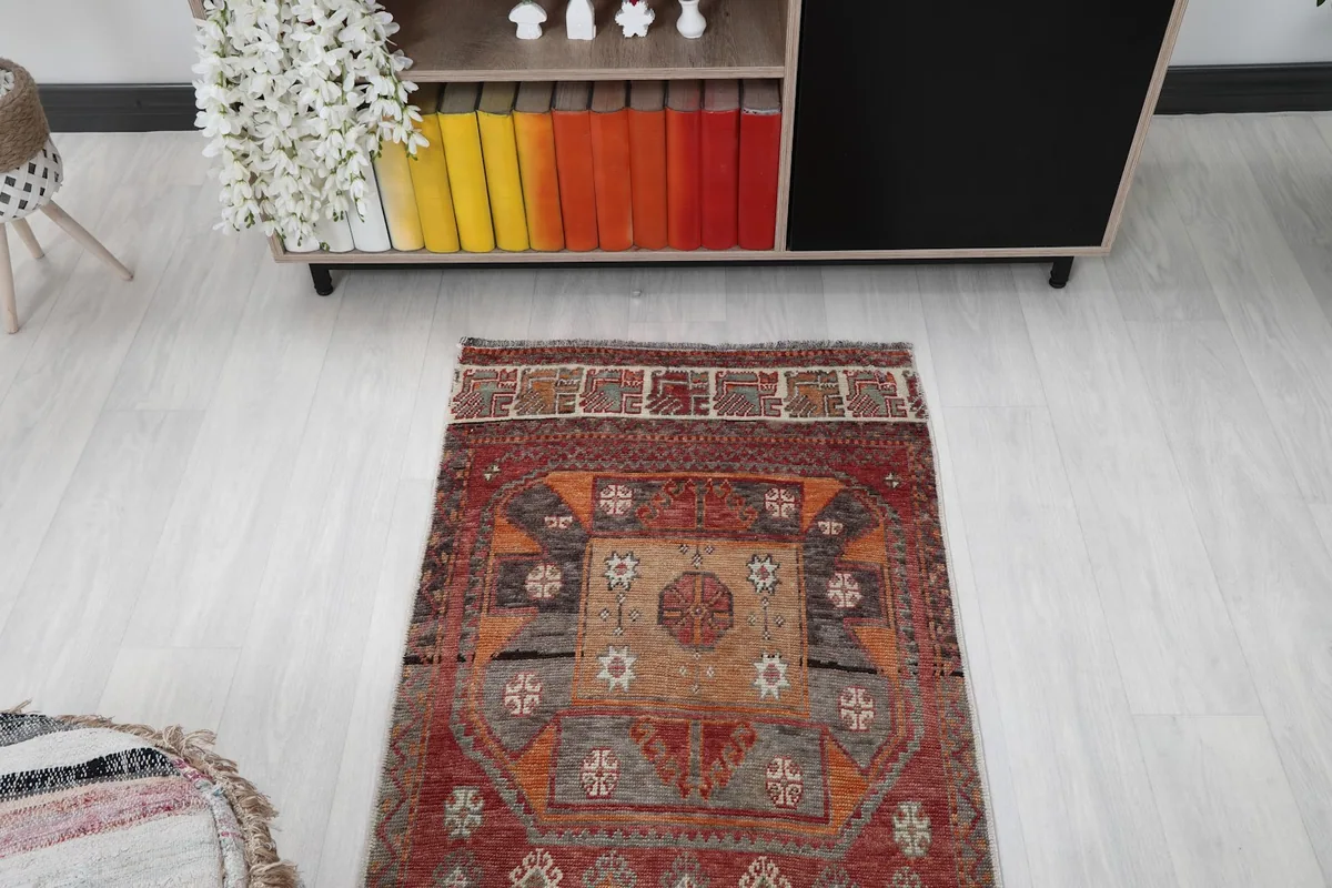 Overhead view of one end of the runner rug, showing its tribal patterns and colors in a room setting