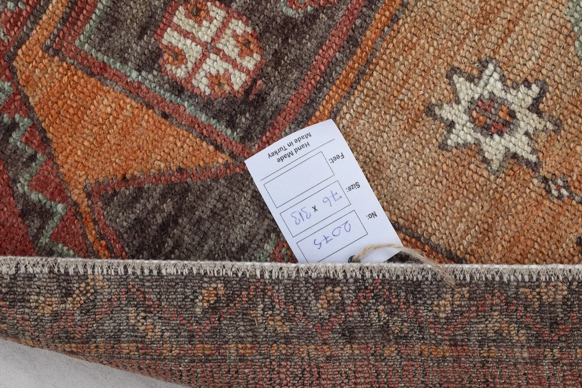 A close-up of the rug's care tag, showing its dimensions and origin, tucked under a corner