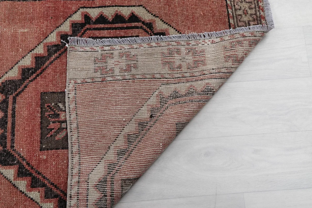 Underside view of the rug, showing the reverse of the hand-knotted wool pile and cotton foundation
