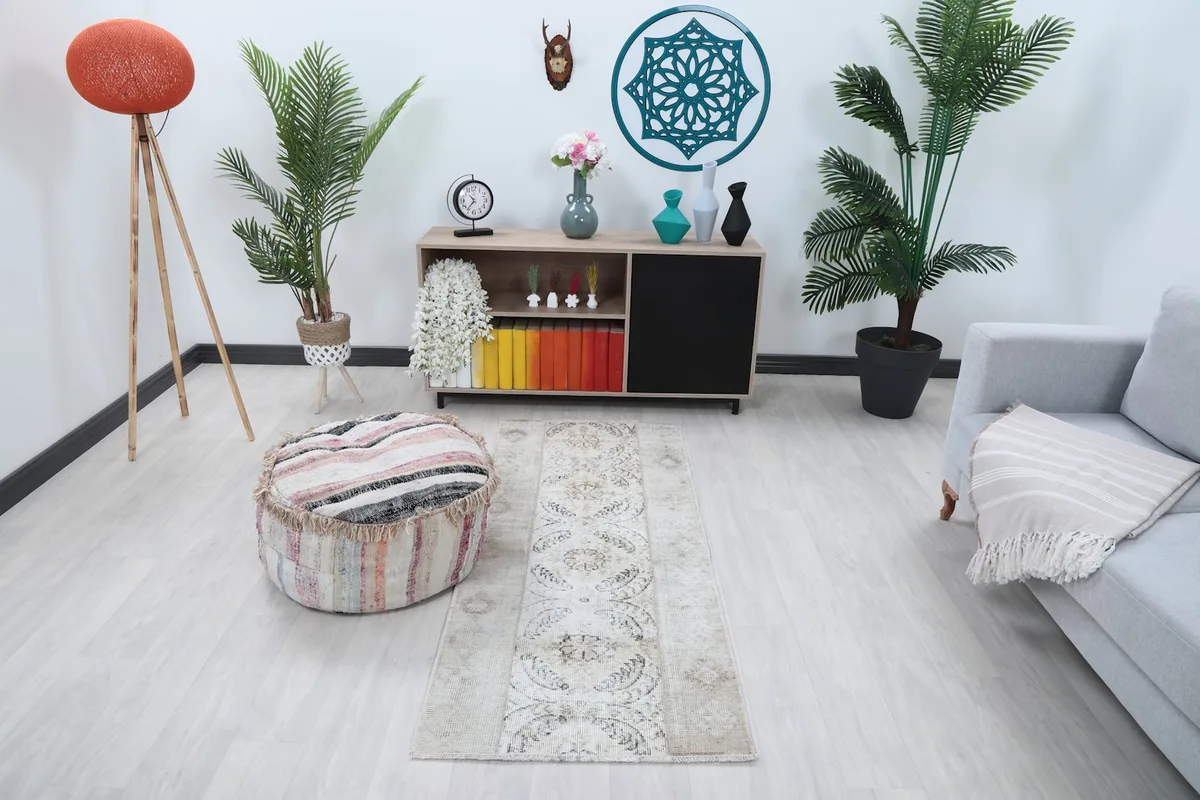 Runner rug placed in a modern living space with a light gray sofa and decorative plants, viewed from an angle.