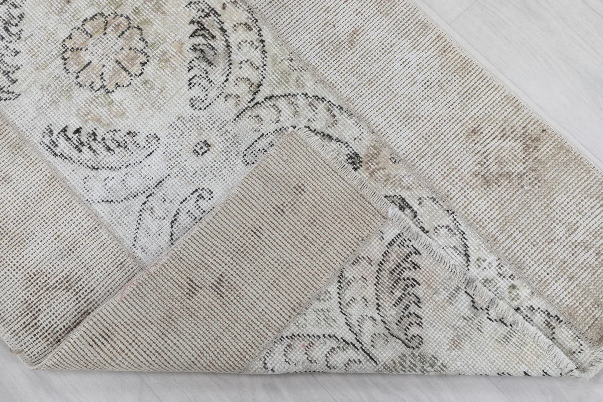 Corner of the rug folded back to reveal the hand-knotted construction on the cotton foundation.