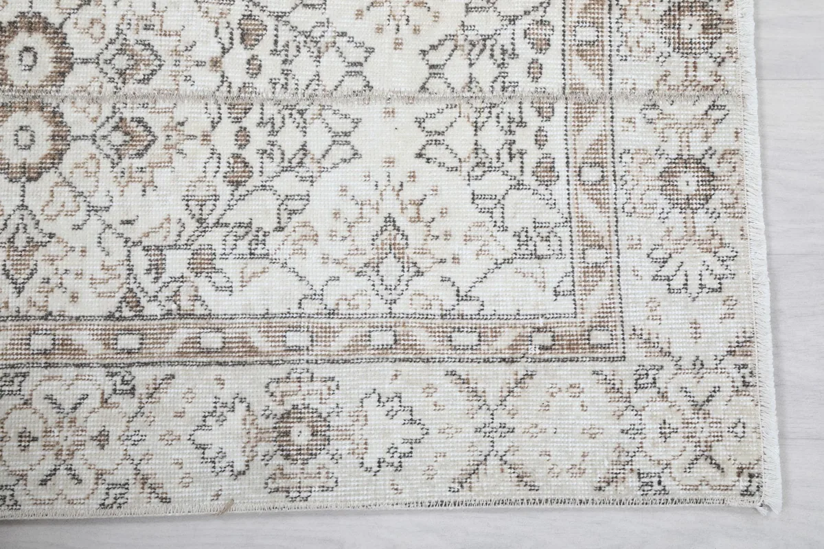 Detailed view of the rug's border and main field floral and geometric motifs.