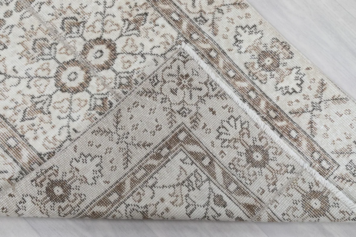 Corner of the rug folded to reveal the hand-knotted cotton foundation.