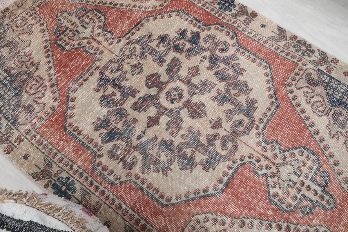 Overhead angle showing the central medallion with blue and rust details on the ivory background