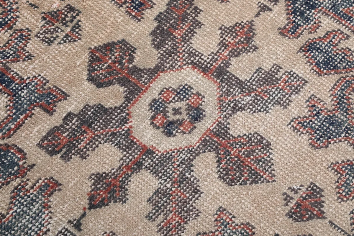 Close-up detail of the hand-knotted wool pile and intricate patterns of the rug
