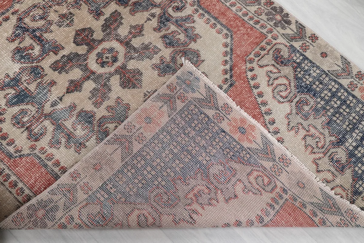 Corner flipped to show the back of the hand-knotted wool rug and cotton foundation