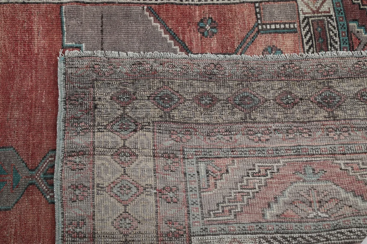 Close-up of the rug's edge and fringe, along with a glimpse of the back.