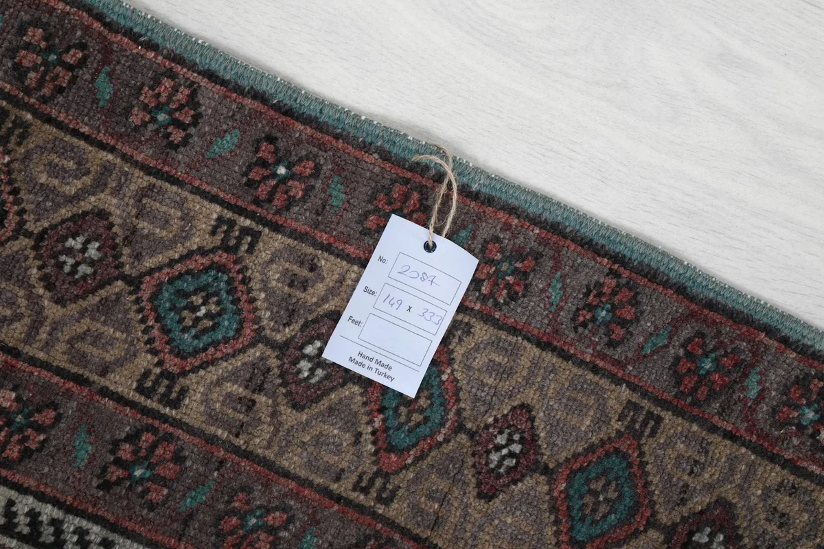 Close-up of the rug's border with a product tag, showing the intricate knotting.