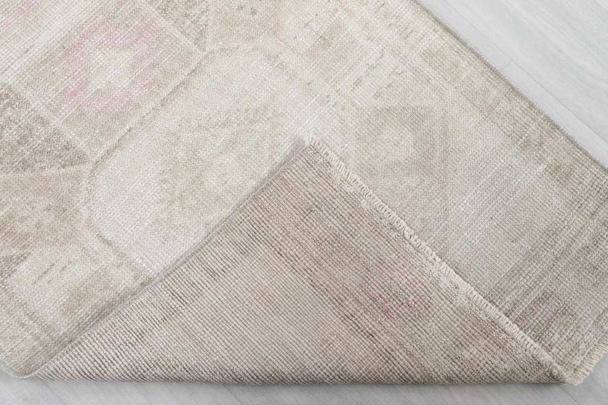 Corner of the rug folded back to show the hand-knotted cotton foundation