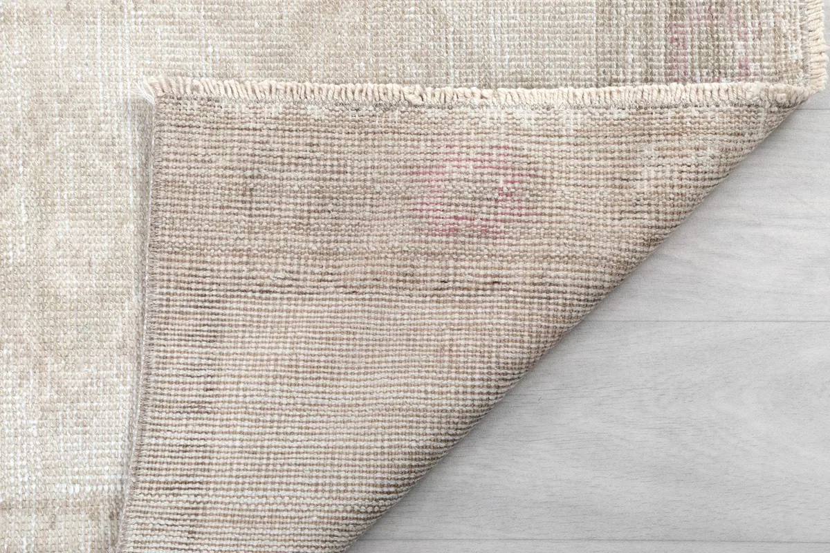 Reverse side of the rug, revealing the hand-knotted construction and fringe