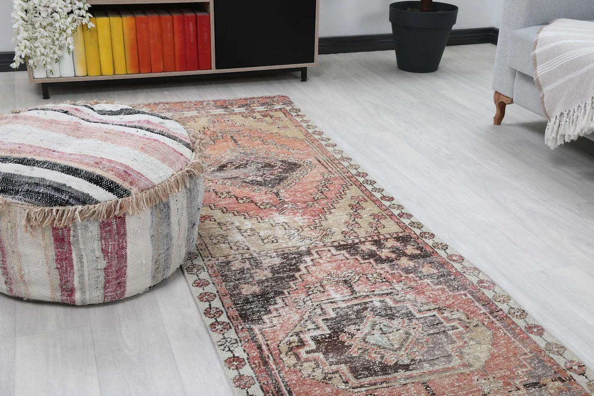 Close-up angle shot of the runner rug and a striped ottoman, showing the rug's texture and colors.
