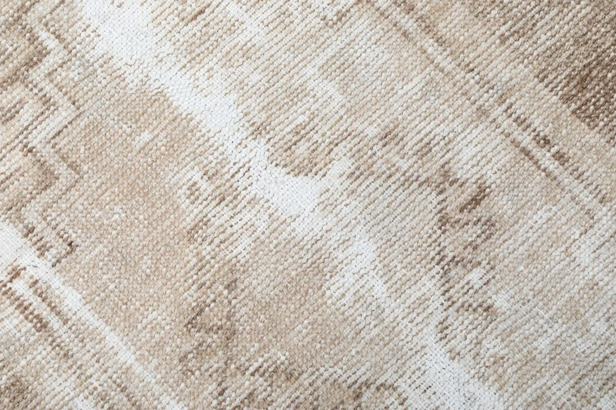 Close-up of the low wool pile, revealing the texture and subtle color variations of the vintage rug.