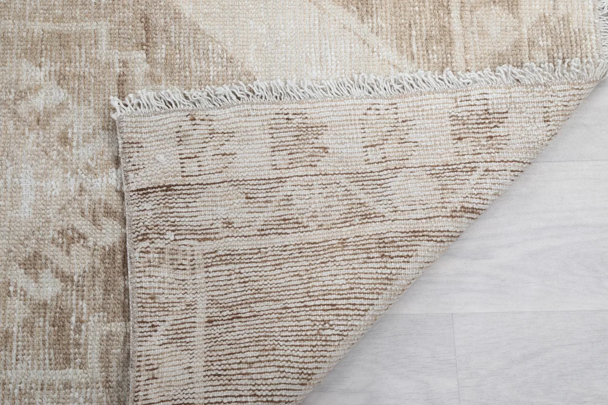 Close-up of the rug's backside, revealing the tight hand-knotting and the cotton foundation structure.