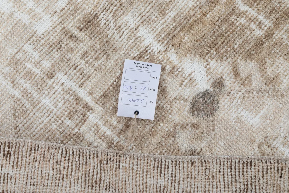 Detail of the rug's texture with a product tag, showing the natural fiber and construction.